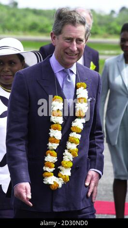 Le Prince de Galles porte une guirlande de fleurs , alors qu'il arrive à l'aéroport international de Georgetown, au Guyana. Banque D'Images