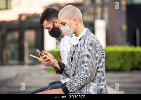 Femme utilisant son téléphone cellulaire pendant une pandémie de covid-19, concepts sur la distanciation sociale, technolegie et le virus corona. Banque D'Images