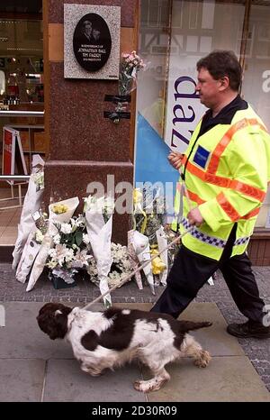 Un chien de sniffer de police et un maître d'œuvre à la recherche par le mémorial de Jonathan ball et Tim Parry à Warrington. La duchesse de Kent doit ouvrir officiellement un centre de paix de 3 millions, dédié aux deux jeunes garçons qui ont perdu la vie dans un attentat à la bombe de l'IRA. Banque D'Images