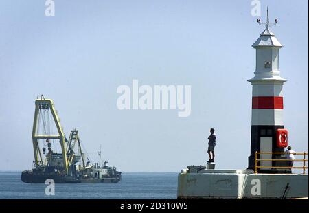 Les habitants de la région regardent de l'extrémité du port de Ramsey jusqu'au Norma qui est ancré à Ramsey Bay, île de Man Tuesday. La Norma continuera à transporter la Solway Harvester, qui a été élevée par la Norma, vers la rive dès que la marée haute arrive plus tard ce soir. * la drague de pétoncles, a coulé avec la perte des sept membres d'équipage, au large de l'île de Man en haute mer en janvier. Banque D'Images