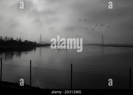 La vue en direction des quais de Southampton et du port de conteneurs depuis le train lorsque la brume matinale commence à se dégager. 12 mars 2014. Photo: Neil Turner Banque D'Images