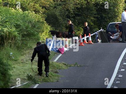 Les fleurs reposent contre un panneau de police sur le côté de l'A29, où les policiers de Sussex se trouvent près de l'endroit où le corps d'une jeune fille a été trouvé dans un champ, au nord de Pulborough. On croit qu'il pourrait manquer Sarah Payne, 8 ans. * qui a disparu le 1/7/00 en jouant dans un champ de maïs près de la maison de Worthing de son grand parent. Les fleurs sont apparues sur les lieux peu après que la police a fermé la route. Banque D'Images