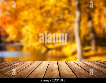 Plateau de table en bois sur fond d'automne flou. Arrière-plan abstrait doré d'automne avec lumière bokeh. Banque D'Images
