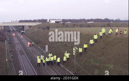 La police fouillant la scène près de Selby, dans le nord du Yorkshire, où treize personnes sont mortes et 70 ont été blessées lorsqu'un train de passagers à grande vitesse a heurté une voiture en fuite (sous le pont, à gauche), puis a heurté un train de marchandises. Les pompiers ont lutté pendant des heures pour libérer les victimes piégées * ... dans l'épave, dont certains ont été entendus tapoter des signaux aux sauveteurs et plaider pour obtenir de l'aide. La scène de la dévastation était sur la ligne principale de la côte est près de Selby dans le nord du Yorkshire. Banque D'Images