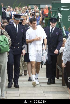 PAS D'UTILISATION COMMERCIALE : le Tim Henman de Grande-Bretagne arrive au court 8 pour s'entraîner à son match contre Goran Ivanisevic de Croatie pendant la deuxième journée de leur match de demi-finale des hommes aux Championnats de tennis de pelouse 2001 à Wimbledon. Banque D'Images