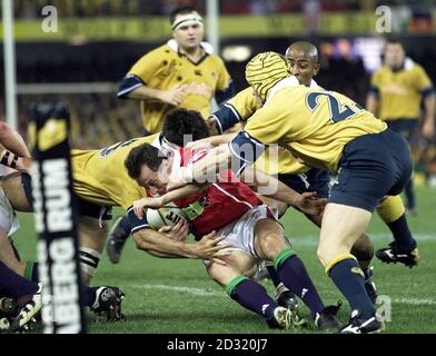 Robert Howley, joueur des Lions britanniques et irlandais, est attaqué par John Eales, George Gregan et Elton Flatley, en Australie, lors du deuxième Test au Colonial Stadium, à Melbourne, en Australie. Howley a été blessé à la suite de ce matériel. Il a été exclu du troisième Test. Banque D'Images