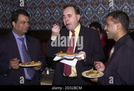 Alex Salmond (au centre) fait la cuisine indienne avec un ancien gagnant du chef indien international de l'année, Shamim Syed (à gauche), et l'organisateur du concours, Tommy Miah, lors d'une réception. * annoncer les finalistes du prix de cette année à la Chambre des communes de Londres. Les huit finalistes, qui comprennent un chef de Bonar Bridge dans l'extrême nord de l'Écosse et une femme thaïlandaise de Birmingham, participeront au Queen Margaret University College d'Édimbourg le 22 février pour le titre, qui est dans sa onzième année. Banque D'Images