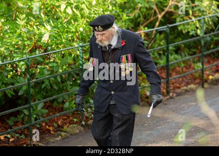 Un homme portant son béret et ses médailles traverse les jardins de Bournemouth après le service du dimanche du souvenir de la ville au Monument commémoratif de guerre. 09 novembre 2014. Photo: Neil Turner Banque D'Images