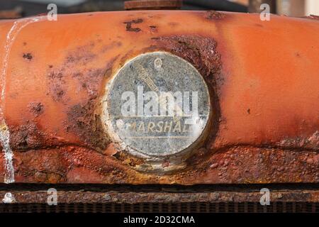 Gros plan d'un badge sur le radiateur avant d'un vieux tracteur Marshall rouillé et abandonné situé sur la plage d'Aldeburgh. ROYAUME-UNI Banque D'Images