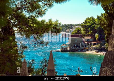 Belle vue sur la plage à travers des branches de pin, bol, île de Brac, Croatie. Mise au point sélective Banque D'Images