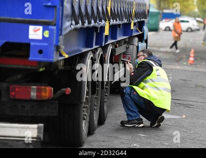 07 octobre 2020, Rhénanie-du-Nord-Westphalie, Cologne: Un employé de l'Agence allemande d'inspection technique (TÜV) inspecte les freins d'un camion. Aujourd'hui, la police de Cologne, avec le TÜV, la société d'essais Dekra et l'Office fédéral du transport de marchandises (BAG), effectue des inspections de camions. Photo: Roberto Pfeil/dpa Banque D'Images