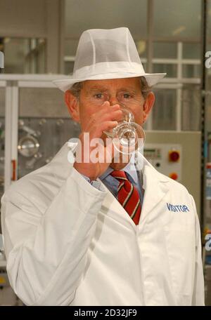 Le Prince de Galles échantillonne un verre d'eau à l'usine de Danone Waters Blaen Twyni, dans la haute vallée de Swansea. Il a visité l'opération d'embouteillage d'eau le premier jour de sa traditionnelle visite d'été de trois jours au pays de Galles. * plus tard, il marquait le centenaire du chemin de fer à vapeur de Llanfair, à Welshpool, avec un trajet sur le chemin de fer léger. Banque D'Images