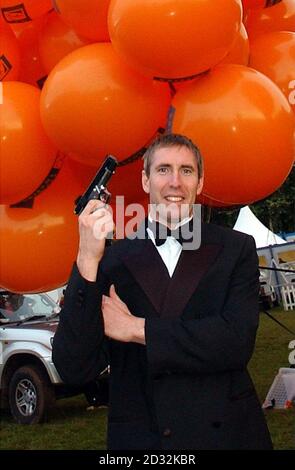 Mike Howard s'est habillé comme James Bond avant de prendre au ciel dangeant sous des centaines de ballons remplis d'hélium de la Bristol Balloon Fiesta. * Howard, habillé comme son héros de daredevil dans une veste de dîner, a augmenté à plus de 7000ft mais a échoué à monter assez haut pour briser le record du monde de 11000ft en raison de la couverture de nuages lourds. Banque D'Images