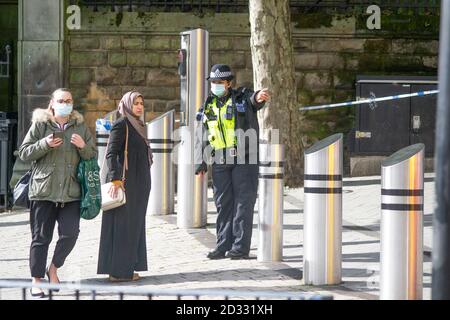 Une femme agent de police des West Midlands donne des indications à une dame autour d'un cordon de police suite à une agression de nuit contre le Marchés de Birmingham Banque D'Images