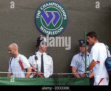 LE joueur DE tennis AMÉRICAIN Andre Agassi et le joueur de tennis australien Mark Philippousis quittent le terrain après leur quatrième match des championnats d'Angleterre de tennis sur gazon à Wimbledon. Banque D'Images