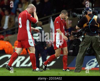 John Hartson (à gauche) et Andy Melville, du pays de Galles, quittent le terrain après avoir perdu 0-1 points en Russie lors de leur deuxième match de match de l'Euro 2004 au Millennium Stadium de Cardiff. Banque D'Images