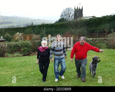 Libéré en otage Mark Henderson avec sa mère Sharelle, son père Christopher et l'animal de compagnie de famille Toby dans leur maison à Pateley Bridge, dans le North Yorkshire. M. Henderson, 32 ans, s'est rendu à Heathrow depuis la Colombie hier, où il a été enlevé par les guérilleros lors d'un voyage de remballage et a passé 102 jours en captivité dans des jungles de montagne éloignées. Après des mois de tension et d'inquiétude, il a finalement été libéré plus tôt cette semaine. Banque D'Images