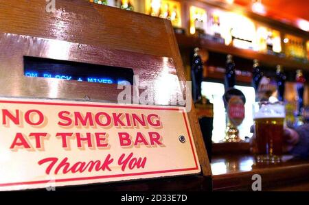 Un panneau « non-fumeurs » placé sur le côté d'un bar dans le centre de Londres. Les militants ont déclaré que plus de vies seraient sauvées en interdisant de fumer dans les lieux publics que ce qui est perdu chaque année dans les accidents de la route. Pour marquer la Journée de non-fumeurs, le directeur de la campagne, Ben Youdan, a déclaré que l'interdiction du tabac dans les pubs, les bars et tous les lieux de travail sauvera 4,800 000 vies par an en Angleterre, au pays de Galles et en Écosse. 07/04/04: Il est apparu aujourd'hui, Tim Martin, le président de JD Wetherspoon, l'une des plus grandes chaînes de pub du Royaume-Uni, a déclaré que le gouvernement devrait envisager une interdiction de fumer dans les pubs à l'échelle nationale. Ses commentaires suivent une interdiction de fumer Banque D'Images