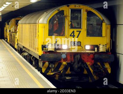 Une Locomotive de batterie souterraine transplantés transporte un train d'ingénierie sur la ligne centrale du métro de Londres (LU) en direction de l'est lorsqu'elle passe à la station Mile End, à l'est de Londres. Banque D'Images