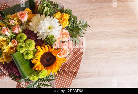 bouquet d'alstroemeria, tournesol, roses, chrysanthème sur fond de bois. composition floristique. Banque D'Images