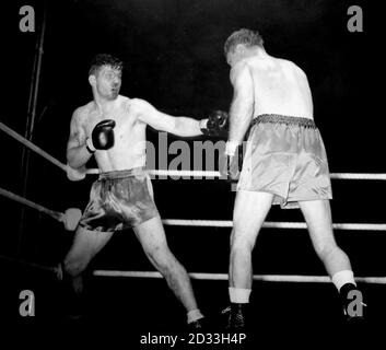 Bruce Woodcock (à gauche) saignant d'un coup sur le nez qu'il a pris dans un premier tour, dans son combat avec Lee Savold au stade de White City. Banque D'Images