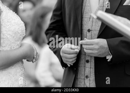 Échange de bague de mariage en gros plan dans les salles blanches et noires main Banque D'Images