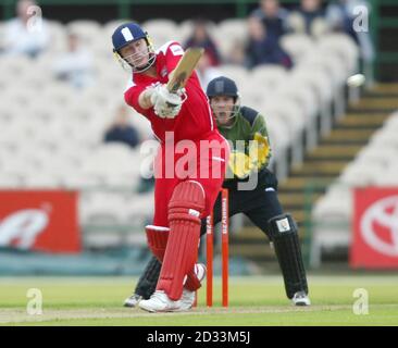 Andrew Flintock, batteur de Lancashire Lightning, touche une limite contre les Outlaws de Notinghamshire en tant que gardien de cricket Chris Read, lors du match de coupe Twenty20 à Old Trafford. Banque D'Images