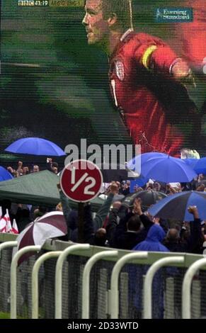 Les spectateurs regardent le capitaine d'Angleterre David Beckham célébrer une pénalité contre l'Argentine lors de leur match de la coupe du monde sur un grand écran de télévision lors des courses d'Epsom. Banque D'Images