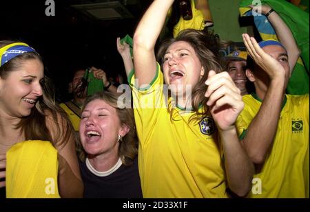 Les fans brésiliens de football fêtent leur équipe devant la Belgique pour assister à la finale de la coupe du monde, tout en regardant le match sur les écrans de télévision du Bar Salsa, dans le centre de Londres. * le Brésil va maintenant rencontrer l'Angleterre dans le quart de finale de la coupe du monde qui sera accueilli par le Japon et le Sud Kourea, ce vendredi prochain. Banque D'Images