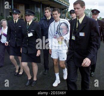 À USAGE ÉDITORIAL EXCLUSIF, PAS D'UTILISATION COMMERCIALE. Les agents de sécurité guident Tim Henman, la première star du tennis britannique, dans la foule du All England Lawn tennis Club. * Henman affronte le joueur suisse Michel Kratochvil dans le troisième tour sur la première court à Wimbledon plus tard cet après-midi. Banque D'Images