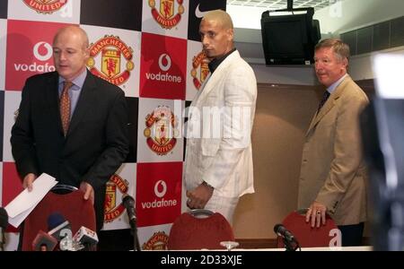 Le nouveau Rio Ferdinard signé par Manchester United est accompagné du chef de l'exécutif du club, Peter Kenyon (à gauche) et du directeur, Alex Ferguson (à droite), au stade Old Trafford du club. L'ancien défenseur de Leeds, âgé de 23 ans, a écrasé les records de frais de transfert britanniques lorsqu'il a traversé les Pennines pour devenir le sixième footballeur le plus cher de tous les temps. Banque D'Images