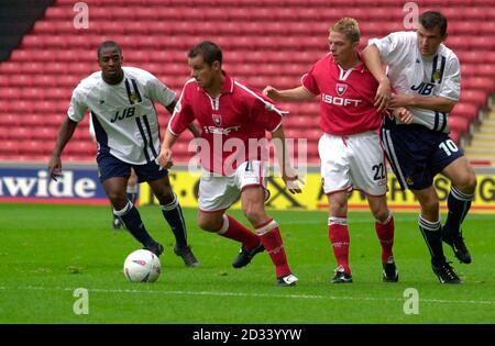 Barnsley's Mitch Ward (2e à gauche) conserve la possession tandis que le coéquipier David Mulligan défie Lee McCulloch de Wigan (tout à droite). Sur (à l'extrême gauche) se trouve Nathan Ellington de Wigan, lors de leur match de la division nationale 2 à Barnsley's Oakwell Ground. CETTE IMAGE NE PEUT ÊTRE UTILISÉE QUE DANS LE CONTEXTE D'UNE FONCTION ÉDITORIALE. PAS D'UTILISATION DU SITE WEB DU CLUB OFFICIEUX. Banque D'Images