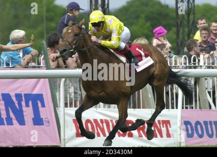 M. Dinos, monté par le jockey Frankie Dettori, remporte les enjeux du Bounusprint Henry II au parc Sandown. Banque D'Images