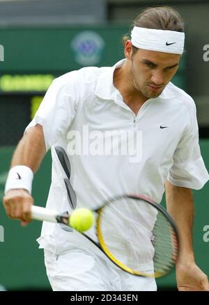 USAGE ÉDITORIAL EXCLUSIF, PAS D'UTILISATION DE TÉLÉPHONE MOBILE. Roger Federer de Suisse en action contre Andy Roddick des Etats-Unis dans la demi-finale masculine aux Championnats de tennis de pelouse de toute l'Angleterre à Wimbledon. Banque D'Images