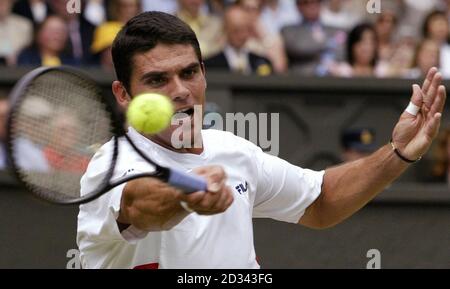 USAGE ÉDITORIAL EXCLUSIF, PAS D'UTILISATION DE TÉLÉPHONE MOBILE. Mark Philippoussis, originaire d'Australie, en action contre Roger Federer, originaire de Suisse, lors de la finale masculine aux championnats d'Angleterre de tennis sur gazon à Wimbledon. Banque D'Images