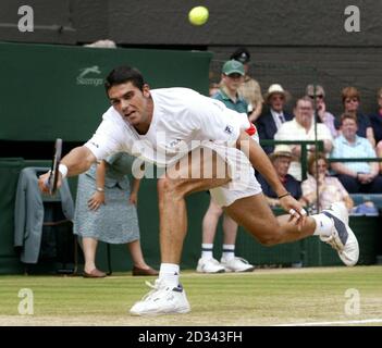 USAGE ÉDITORIAL EXCLUSIF, PAS D'UTILISATION DE TÉLÉPHONE MOBILE. Mark Philippoussis, originaire d'Australie, en action contre Roger Federer, originaire de Suisse, lors de la finale masculine aux championnats d'Angleterre de tennis sur gazon à Wimbledon. Banque D'Images