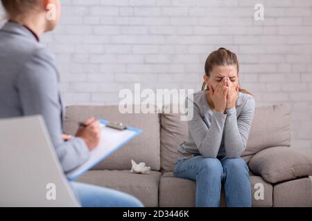 Concept de santé mentale et d'aide psychologique. Jeune femme avec dépression sur la séance de conseil avec thérapeute à la clinique Banque D'Images