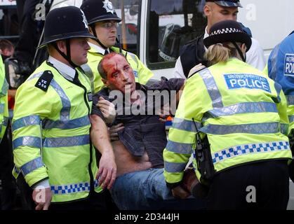 Un membre du public est aidé par des policiers sur la place du Parlement, dans le centre de Londres, pendant les troubles, avant le vote sur un projet de loi controversé qui pourrait finalement voir la chasse au renard et les cours de lièvres interdites en Angleterre et au pays de Galles. Le projet de loi sur la chasse sera mis en urgence à la Chambre des communes en une seule journée, et le gouvernement a clairement indiqué que, si les députés votaient pour une interdiction, il invoquera la Loi du Parlement pour annuler la résistance attendue des lords. Banque D'Images