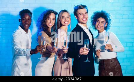 Joyeux collègues divers tenant des lunettes de champagne à la fête de Noël de bureau Banque D'Images