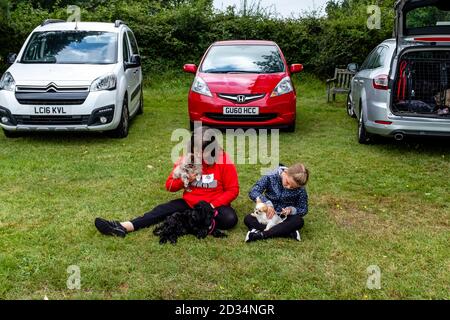 Les gens de la région attendent avec leurs chiens le début du spectacle des chiens à Framfield et le spectacle d'été des Blackboys à Framfield, East Sussex, Royaume-Uni Banque D'Images