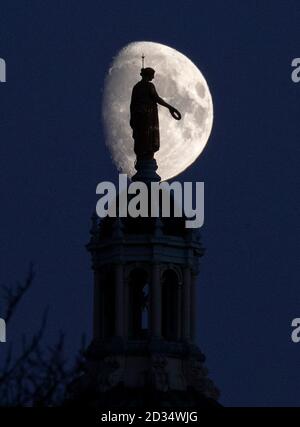 La statue dorée de la victoire, qui tient une couronne de Laurier, sur le dôme central du siège de la Banque d'Écosse à Édimbourg, est silhouetée contre une lune de gibbous cirant. Banque D'Images