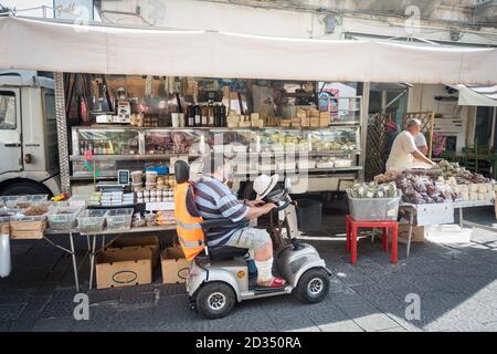 Homme en fauteuil roulant dans un marché, stalle le célèbre marché aux poissons d'Ortygia à Syracuse. Ortygia est une île dans la ville sicilienne de Syracuse, on Banque D'Images