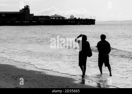 Un couple de marche en pagayant dans la mer alors qu'ils se dirigent vers l'ouest en direction de Bournemouth Pier. 15 juillet 2014. Photo: Neil Turner Banque D'Images