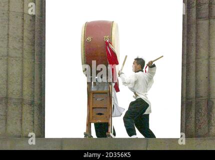 Tuek Hu Ha, un batteur coréen traditionnel de Dulsori, se produit avec son tambour de 2 mètres de haut dans le cadre de son Edinburgh Festival Fringe Act sur Calton Hill, à Édimbourg. Banque D'Images