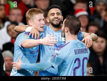 Manchester City's Riyad Mahrez (centre) célèbre marquant son deuxième but de côtés du jeu avec ses coéquipiers Kevin De Bruyne (à gauche) et Bernardo Silva lors de la demi-finale de la Coupe du buffle premier match aller à Old Trafford, Manchester. Banque D'Images