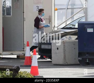 Remarque : les plaques d'immatriculation sont pixellisées par PA Picture Desk. Une personne tient un écouvillon dans un centre d'essai routier de Covid-19 pour les travailleurs du NHS qui a ouvert ses portes au magasin d'Ikea à Wembley, au nord-ouest de Londres. Banque D'Images