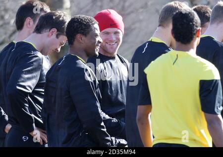 Wayne Rooney de Manchester United avec Patrice Evra lors d'une session d'entraînement au terrain d'entraînement de Carrington, à Manchester. Banque D'Images