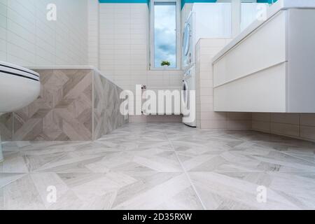 Salle de bains après rénovation. Nouveau carrelage en pierre au sol de la salle de bains. Rénovation et amélioration de la maison concept. Personne Banque D'Images