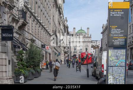 Regent Street St James's, Londres, Royaume-Uni. 7 octobre 2020. Le soleil du matin dans l'extrémité ouest. Au centre, un pilote sur un scooter électrique conduit le long de la chaussée à grande vitesse donnant à tous ceux qui se plaignent du doigt et de la courbure. Crédit : Malcolm Park/Alay Live News. Banque D'Images