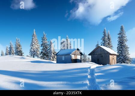 Paysage d'hiver fantastique avec maison en bois dans les montagnes enneigées. Concept de vacances de Noël Banque D'Images